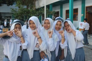 Siswa-siswi menunjukkan jari kelingking tanda telah melakukan pencoblosan